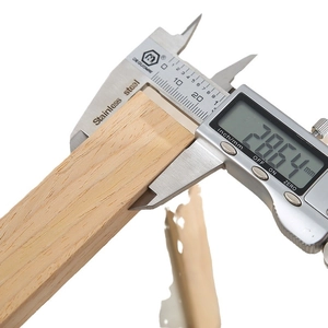 Digital stainless steel caliper measuring a wood piece with precise LCD reading display