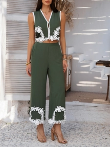 Détail d'un ensemble bohème avec broderie florale ajourée blanche sur tissu vert élégant
