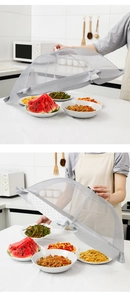 Macro detail of foldable gray mesh food cover protecting dishes on a kitchen counter