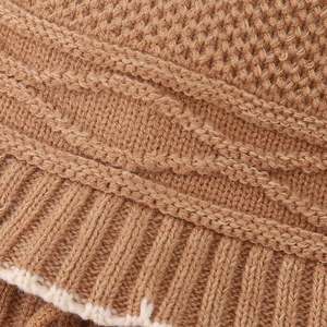 Macro detail of brown ribbed knit children's hat showing textured weave and cream edge
