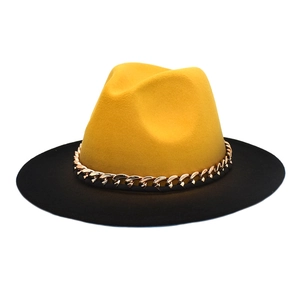Détail d'un chapeau en laine avec couronne jaune, bord noir et chaîne dorée chic
