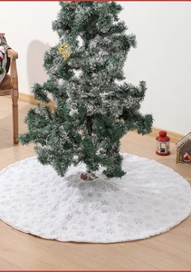Close-up of white plush Christmas tree skirt with silver snowflake embroidery details