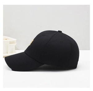 Close-up of black cotton baseball cap with gold NY embroidery and breathable eyelets
