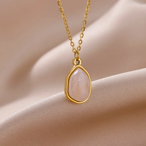 Detailed view of the 18K gold plated teardrop pendant with a translucent gem on silk