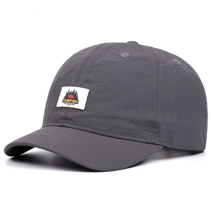 Detail of a dark grey quick-dry baseball cap featuring a short brim and camping patch