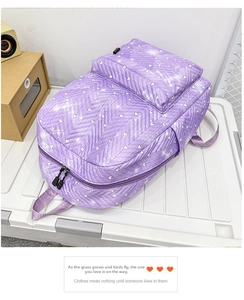 Detalle de mochila acolchada morada con patrones de corazones blancos y acabado brillante