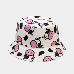 Close-up of high-quality white bucket hat with cute black and pink cartoon cow pattern