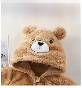 Détail d'une grenouillère en peluche pour bébé avec oreilles et texture douce