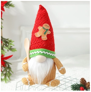 Close-up of red knit Christmas gnome with gingerbread patch and wooden spoon accessory