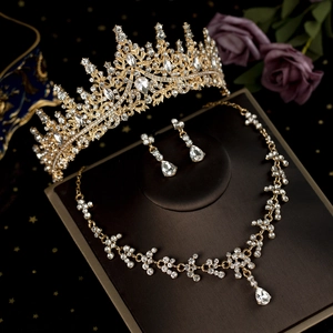 Close-up of golden bridal jewelry set with sparkling crystals on a vintage display stand