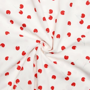 Gros plan du tissu blanc doux avec motifs de baies rouges et drapé fluide élégant