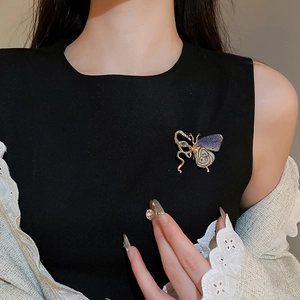 Detailed view of an exquisite purple butterfly brooch with crystals on white knitwear