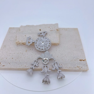 Close-up of a silver floral hollow pendant with white rhinestones on natural stones
