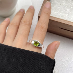 Close-up of S925 sterling silver ring with olive green star-shaped gemstone on hand