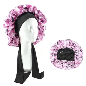 Detailed view of floral pink satin sleep cap with adjustable wide black elastic straps