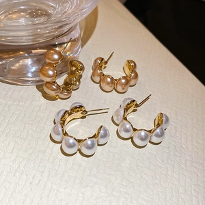Detailed macro view of French vintage C-shape gold-plated pearl hoop earrings set