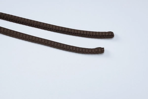 Detailed macro view of brown ribbed texture flat drawstrings on a stylish dress