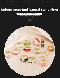 Detail of adjustable gold rings with colorful enamel, natural stones and evil eye motif