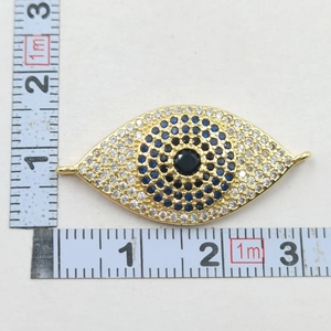 Macro shot showing dimensions of gold-plated evil eye pendant with blue zircon stones