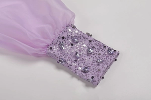 Macro detail of lavender sleeve featuring intricate hand-beaded sequins on sheer fabric