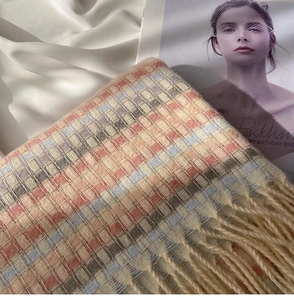 Macro shot of colorful plaid scarf with soft woven texture and long beige tassels