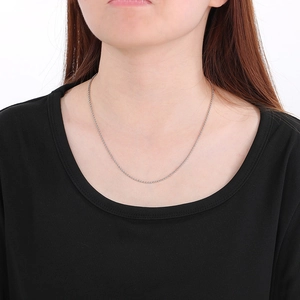 Détail d'un collier chaîne à billes en acier inoxydable argenté porté sur modèle