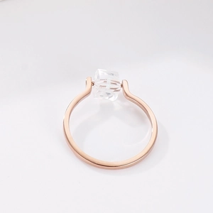 Detailed view of a minimalist rose gold ring with a sparkling cubic zircon pendant