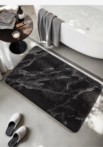 Detail of black marble pattern bath mat with soft absorbent fiber texture in modern bathroom