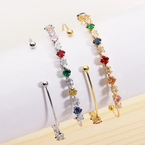 Close-up of rainbow zircon inlaid bracelets and gold-plated minimalist bead bangles