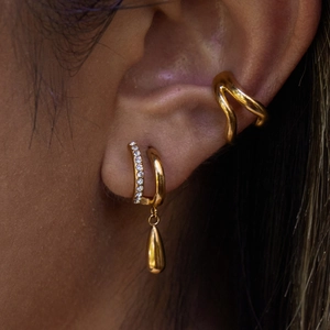 Gros plan sur l'oreille avec manchette dorée double couche et boucles d'oreilles