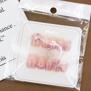 Pink gradient press-on nails with 3D rainbow butterflies and pearls in M size packaging