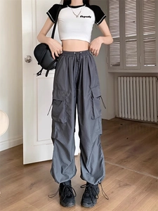 Close-up of dark grey cargo pants with multiple pockets and drawstring waist detail