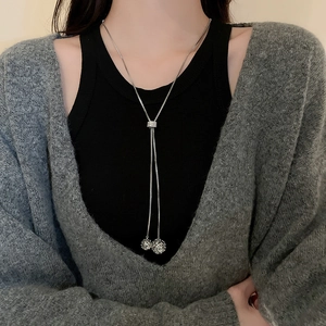 Close-up of adjustable silver long necklace with hollow spherical pendants and sliding clasp