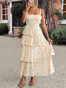 Detail of tiered ruffle design on a white floral print summer maxi dress in a garden