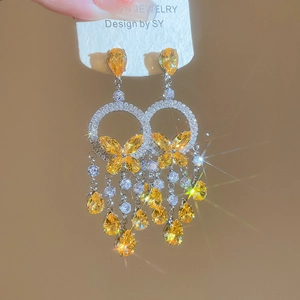 Detail of silver drop earrings with yellow butterflies and sparkling teardrop crystals