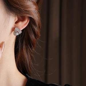 Gros plan d'élégantes boucles d'oreilles triangles en argent avec zircon sur un mannequin