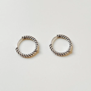 Macro detail of twisted rope hoop earrings crafted in 925 sterling silver with a vintage finish