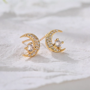 18K gold plated moon stud earrings with micro-pave cubic zirconia on stone background
