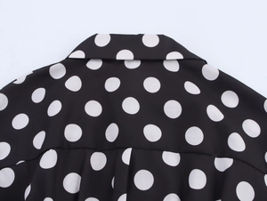 Detailansicht der Retro-Polka-Dots auf dem schwarzen Vintage-Blusenkragen und Rücken