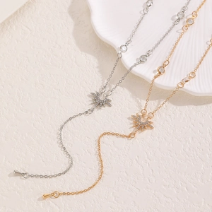 Colliers en Y tendance dorés et argentés avec pendentifs étoiles sur un plateau coquillage