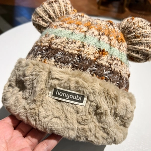 Detail showing knit texture and faux fur trim of the thick warm winter earflap hat