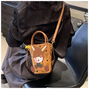 Detail of a brown bucket bag with a 3D bunny mascot and classic monogram pattern