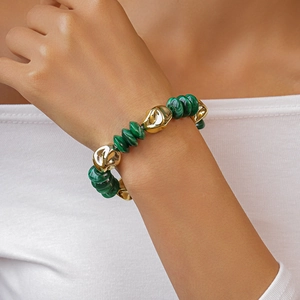 Detail of vintage beaded bracelet featuring dark green stones and irregular gold accents