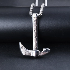 Detailed view of silver axe pendant with hammer texture and vintage punk style metalwork