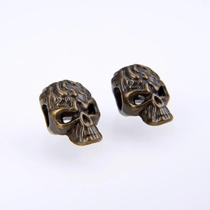 Detailed macro view of vintage bronze skull beads for DIY jewelry with side holes