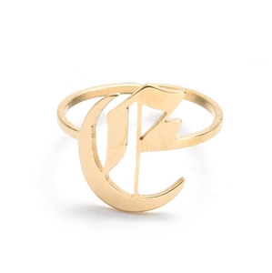 Detailed macro view of a vintage gold-plated stainless steel ring with Gothic letter E
