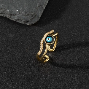 Macro detail of gold evil eye ring with white cubic zirconia and blue enamel inlays