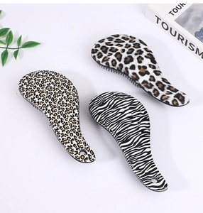 Detailed top view of three hairbrushes with leopard and zebra animal prints