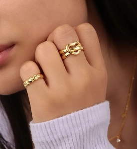 Detail of elegant gold-plated heart rings with hollow and micro-heart patterns on hands