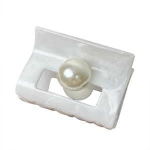 Elegant pearlescent white square claw clip with a large central pearl on white background